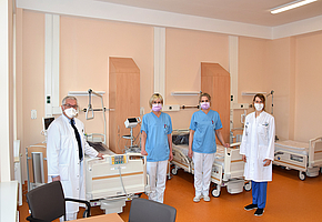 Zwei Ärzte und zwei Schwestern stehen in einem Zimmer mit drei leeren Betten, dermatologie uni rostock