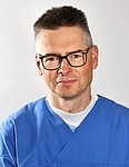 Mann mit Brille in blauer Dienstkleidung, Hautklinik rostock