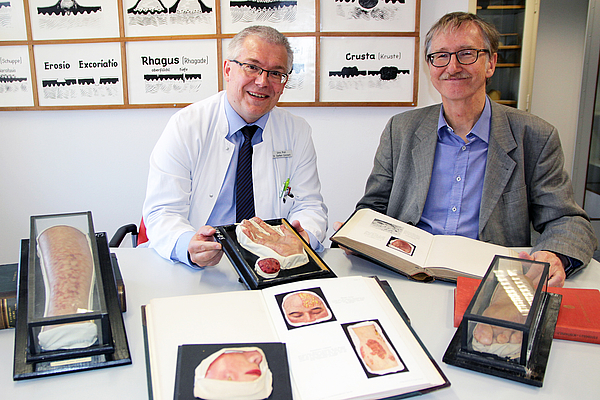 Prof. Dr. Steffen Emmert (l.) und Prof. Dr. Hans-Uwe Lammel (ehm. Direktor des Arbeitsbereichs Geschichte der Medizin) arbeiten die Moulagen-Sammlung auf.